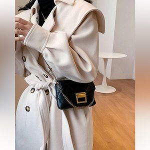 Black quilted crossbody bag with gold chain.